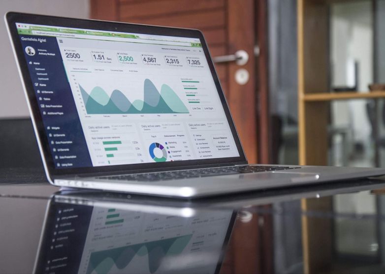 Masa üstünde duran bir laptop ve ekranında istatistikler