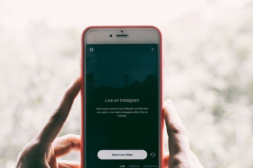 İki el, Instagram canlı yayınına başlama ekranı gösteren bir telefon tutuyor.