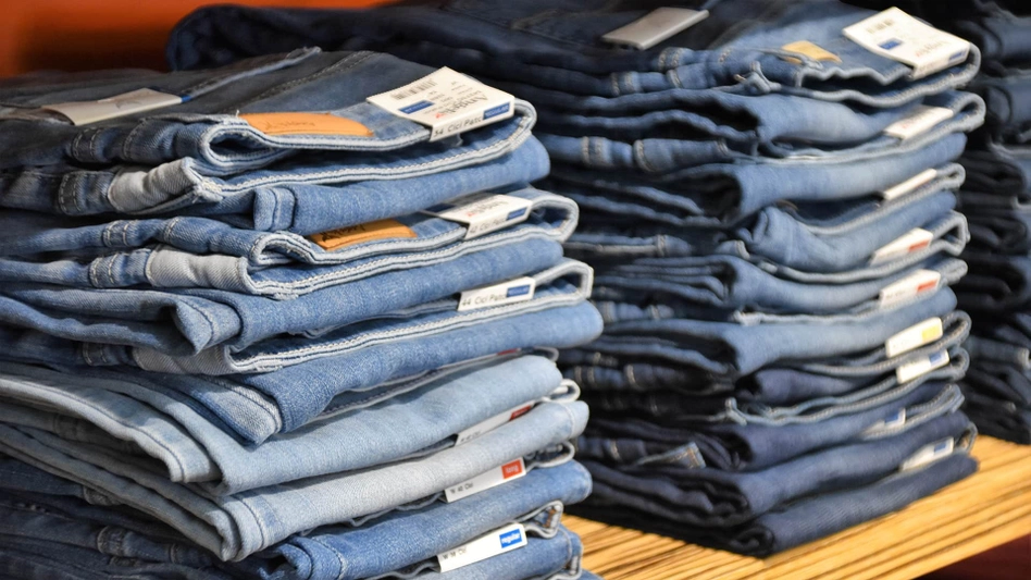 A stack of wholesale jeans of a wholesale jeans supplier on a shelf