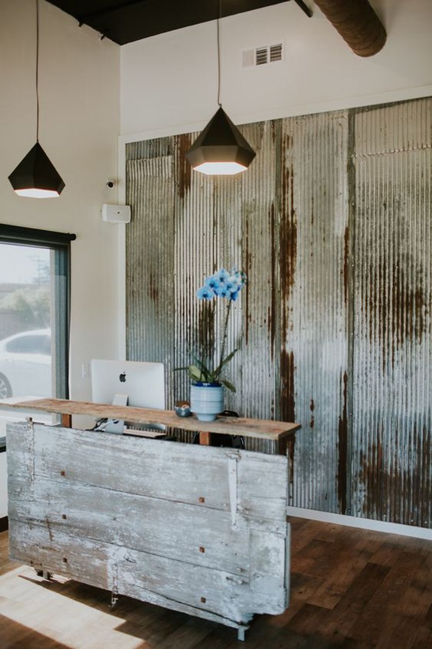 Una reception rustica con legno riciclato all'interno di una piccola boutique di abbigliamento