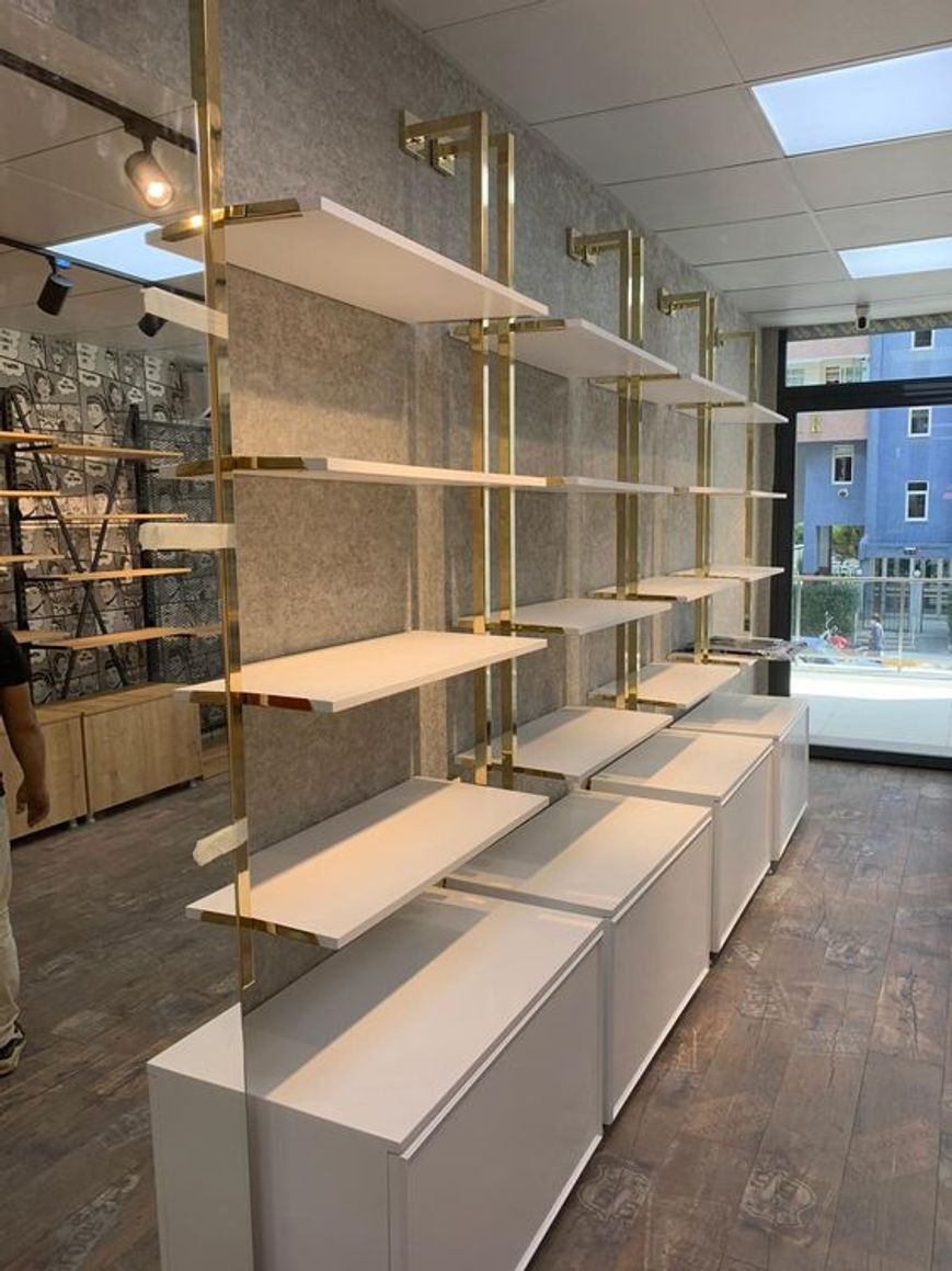 Scaffali vuoti verticali, bianchi e alti per l'interior design di piccole boutique di abbigliamento