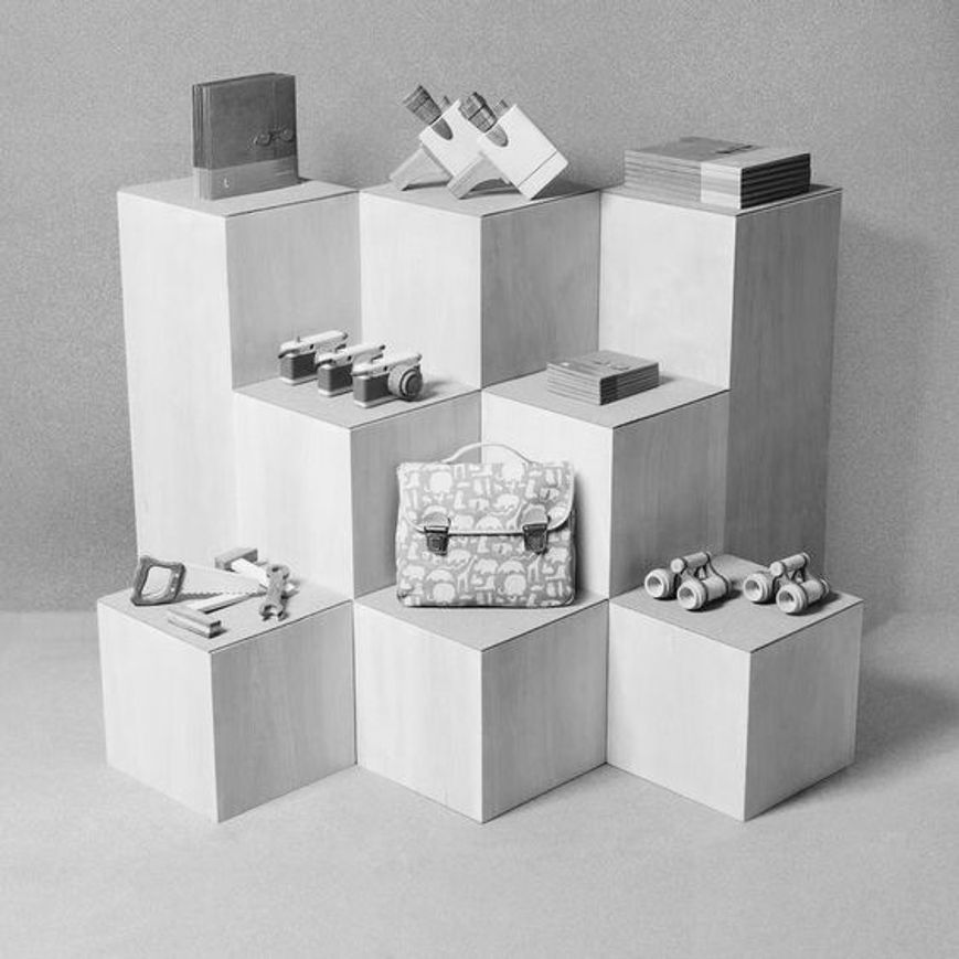 Un espositore simmetrico in grigio e bianco per l'interior design di piccole boutique di abbigliamento