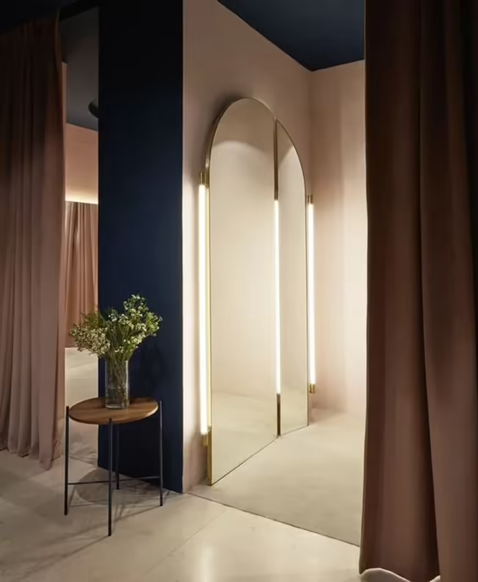 Het interieur van een kledingwinkel met planten, een stoel en decoratieve verlichting