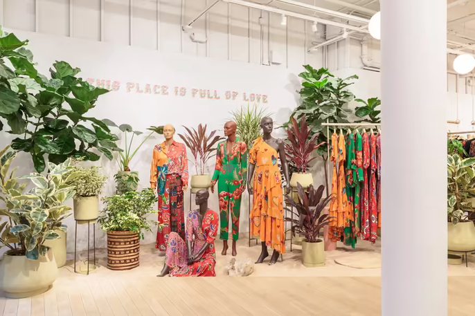Een levendig winkelinterieur versierd met authentieke kleurrijke kleding en decoratieve planten