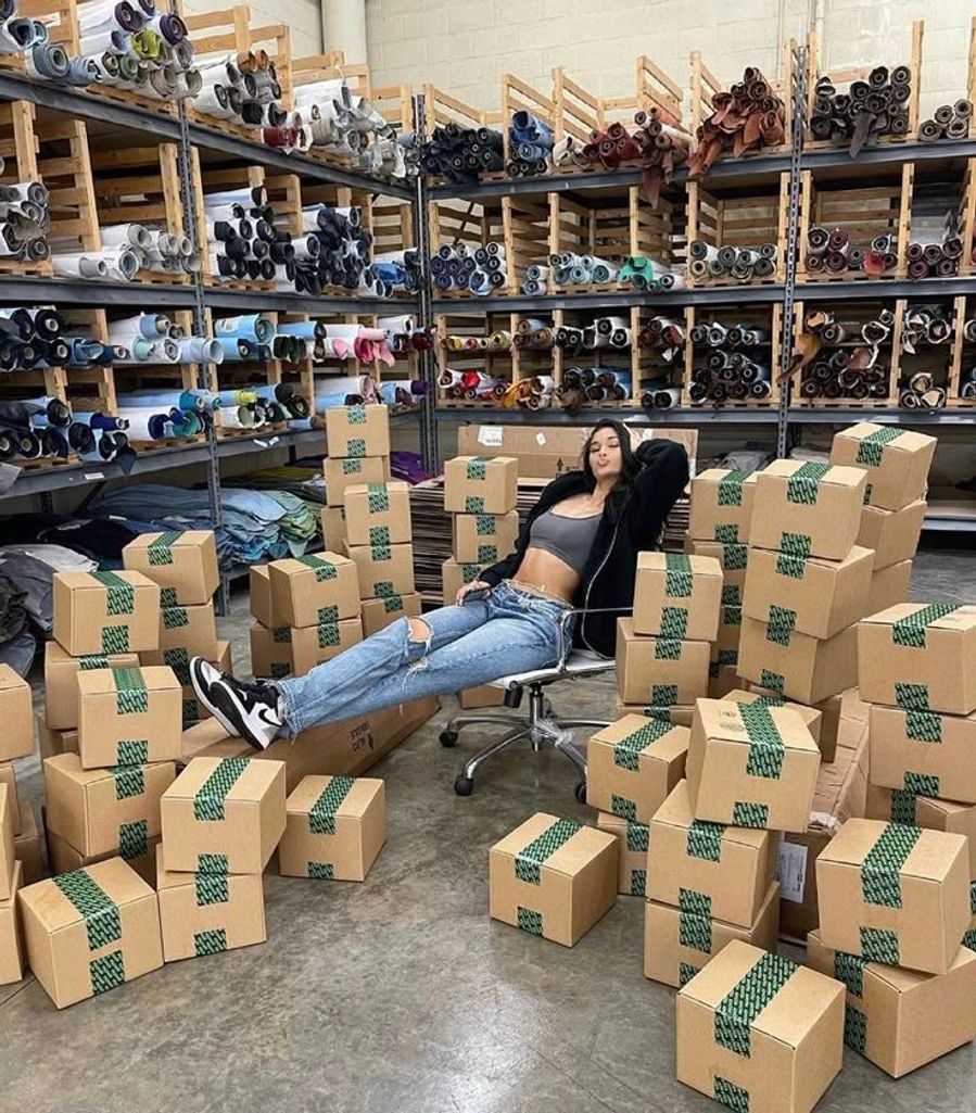 Butik sahibi, toptan kadın giyim siparişleriyle poz veriyor.