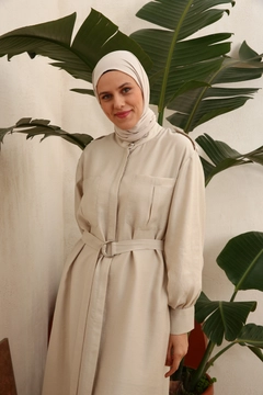 Bir model, Allday toptan giyim markasının 48115 - Abaya - Beige toptan Ferace ürününü sergiliyor.