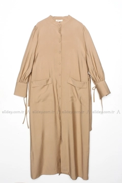 Bir model, Allday toptan giyim markasının 7495 - Modest Abaya - Beige toptan Ferace ürününü sergiliyor.