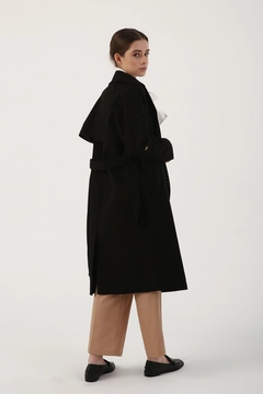 Bir model, Allday toptan giyim markasının 7771 - Modest Trenchcoat - Black toptan Trençkot ürününü sergiliyor.