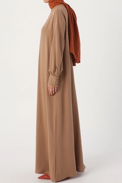 Bir model, Allday toptan giyim markasının 16299 - Abaya - Earth Colour toptan Ferace ürününü sergiliyor.