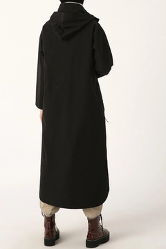 Bir model, Allday toptan giyim markasının 22009 - Trenchcoat - Black toptan Trençkot ürününü sergiliyor.
