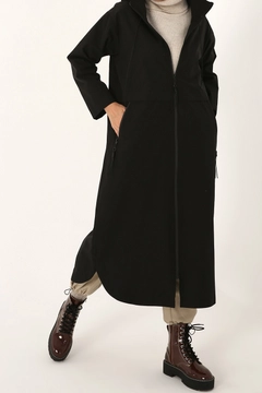 Bir model, Allday toptan giyim markasının 22009 - Trenchcoat - Black toptan Trençkot ürününü sergiliyor.