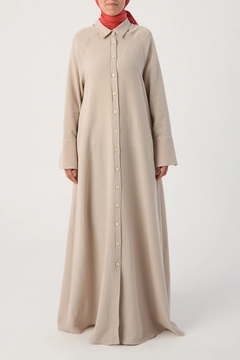 Bir model, Allday toptan giyim markasının 22012 - Abaya - Beige toptan Ferace ürününü sergiliyor.