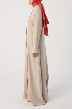 Bir model, Allday toptan giyim markasının 22012 - Abaya - Beige toptan Ferace ürününü sergiliyor.