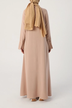 Bir model, Allday toptan giyim markasının 22126 - Abaya - Dark Beige toptan Ferace ürününü sergiliyor.