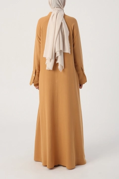 Bir model, Allday toptan giyim markasının 28345 - Abaya - Mustard toptan Ferace ürününü sergiliyor.