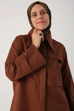 Bir model, Allday toptan giyim markasının ALL10630 - Light Brown Pointed Collar Hidden Pop Abaya - Brown toptan Ferace ürününü sergiliyor.