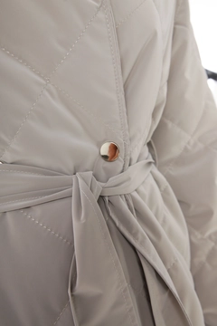 Una modella di abbigliamento all'ingrosso indossa all11770-quilted-coat-with-snap-fastener-belt-stone-color, vendita all'ingrosso turca di Cappotto di Allday