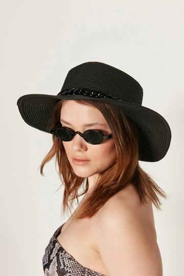 Bir model, Axesoire toptan giyim markasının  Zincirli  Geniş Hasır Şapka - Siyah
 toptan Şapka ürününü sergiliyor.
