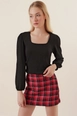 Bir model,  toptan giyim markasının 42914-blouse-black toptan  ürününü sergiliyor.