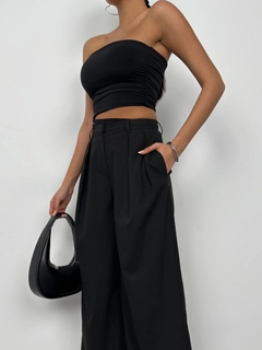 Een kledingmodel uit de groothandel draagt bla11425-asymmetric-strapless-crop-black, Turkse groothandel Crop-top van Black Fashion