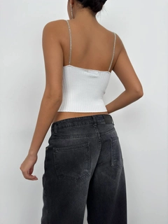 Bir model, Black Fashion toptan giyim markasının bla11501-stone-strap-knitted-blouse-ecru toptan Crop Top ürününü sergiliyor.