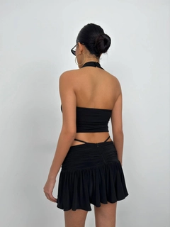 Bir model, Black Fashion toptan giyim markasının bla11534-cross-strap-blouse-black toptan Crop Top ürününü sergiliyor.