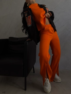 Bir model, Black Fashion toptan giyim markasının 37887 - Tracksuit - Orange toptan Eşofman Takımı ürününü sergiliyor.