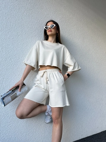 Bir model, CAPPITONE toptan giyim markasının  Pis Dikişli Sade Şortlu Takim Kutup Beyaz
 toptan Takım ürününü sergiliyor.