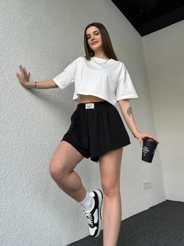 Una modella di abbigliamento all'ingrosso indossa  Pantaloncini Etichettati Neri
, vendita all'ingrosso turca di Pantaloncini di CAPPITONE