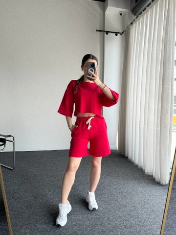 Bir model, CAPPITONE toptan giyim markasının  Pis Dikişli Sade Şortlu Takım Kırmızı
 toptan Takım ürününü sergiliyor.