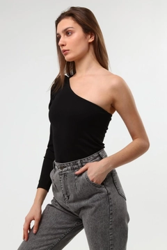 Bir model, Evable toptan giyim markasının 2599 - Heght One-Sleeve Wrinkle-Free Fabric Women's Blouse- Black toptan Bluz ürününü sergiliyor.