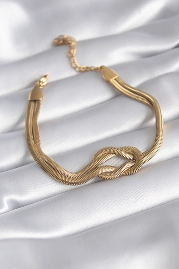 Bir model, Ebijuteri toptan giyim markasının  316L Çelik Gold Renk İtalyan Zincir Düğüm Model Kadın Bileklik
 toptan Bileklik ürününü sergiliyor.