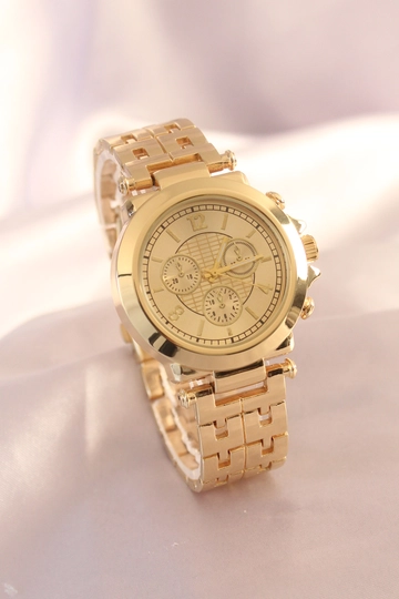 Bir model, Ebijuteri toptan giyim markasının  Gold Renk Metal Kordon Gold Kasa Kadın Saat
 toptan Saat ürününü sergiliyor.