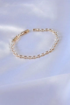 Bir model, Ebijuteri toptan giyim markasının EBJ10685 - 316L Steel Gold Color Barley Zircon Stone Waterway Women's Bracelet toptan Bileklik ürününü sergiliyor.