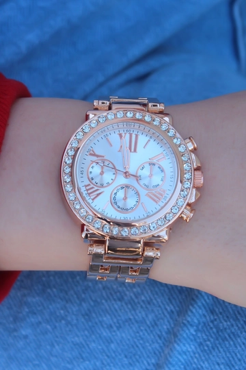 Een kledingmodel uit de groothandel draagt  Roze metalen band, dameshorloge met witte wijzerplaat, Romeins cijfer en zirkoonsteen
, Turkse groothandel Horloge van Ebijuteri