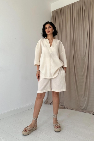 Bir model, Elisa toptan giyim markasının  Şort Ve Üst Takım - Bej
 toptan Takım ürününü sergiliyor.