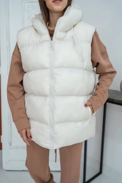 Bir model, Elisa toptan giyim markasının ELS10024 - Hooded Inflatable Vest - Ecru toptan Yelek ürününü sergiliyor.