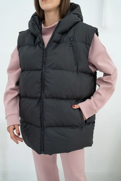 Bir model, Elisa toptan giyim markasının ELS10025 - Hooded Inflatable Vest - Black toptan Yelek ürününü sergiliyor.