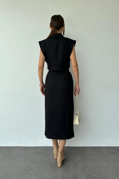 Bir model, Elisa toptan giyim markasının ELS10105 - Vest & Skirt Suit With Front And Side Buttons - Black toptan Takım ürününü sergiliyor.