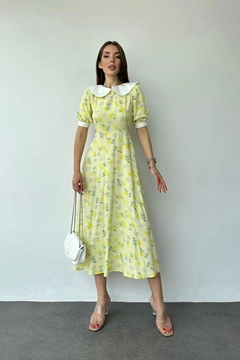 Bir model, Elisa toptan giyim markasının ELS10113 - Bib Collar Floral Pattern Dress - Yellow toptan Elbise ürününü sergiliyor.