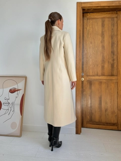Un mannequin de vêtements en gros porte els11466-pocket-chain-coat-beige, Manteau en gros de Elisa en provenance de Turquie