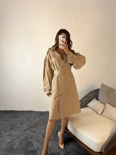 Bir model, Fame toptan giyim markasının 29694 - Trenchcoat - Beige toptan Trençkot ürününü sergiliyor.