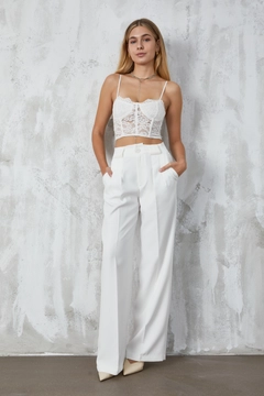 Bir model, First Angels toptan giyim markasının fan10294-ecru-atlas-fabric-palazzo-trousers toptan Pantolon ürününü sergiliyor.
