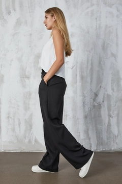 Ein Bekleidungsmodell aus dem Großhandel trägt fan10297-black-atlas-fabric-palazzo-trousers, türkischer Großhandel Hose von First Angels