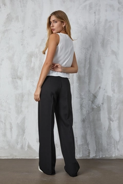 Ein Bekleidungsmodell aus dem Großhandel trägt fan10297-black-atlas-fabric-palazzo-trousers, türkischer Großhandel Hose von First Angels