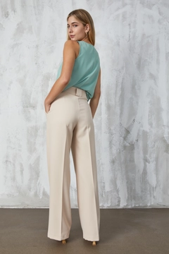 Bir model, First Angels toptan giyim markasının fan10298-stone-atlas-fabric-palazzo-trousers toptan Pantolon ürününü sergiliyor.