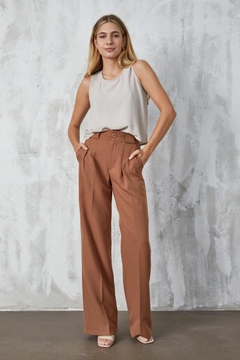 Bir model, First Angels toptan giyim markasının fan10299-mink-atlas-fabric-palazzo-trousers toptan Pantolon ürününü sergiliyor.