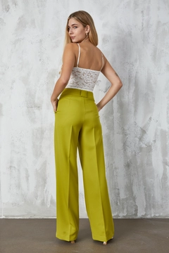 Bir model, First Angels toptan giyim markasının fan10300-green-atlas-fabric-palazzo-trousers toptan Pantolon ürününü sergiliyor.