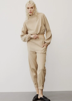 Bir model, Fk.Pynappel toptan giyim markasının 31758 - Tracksuit - Beige toptan Eşofman Takımı ürününü sergiliyor.