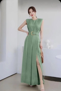 Bir model, My Jest Fashion toptan giyim markasının MJF10003 - Shoulder Wadding Detail Leg Slit Belt Dress toptan Elbise ürününü sergiliyor.